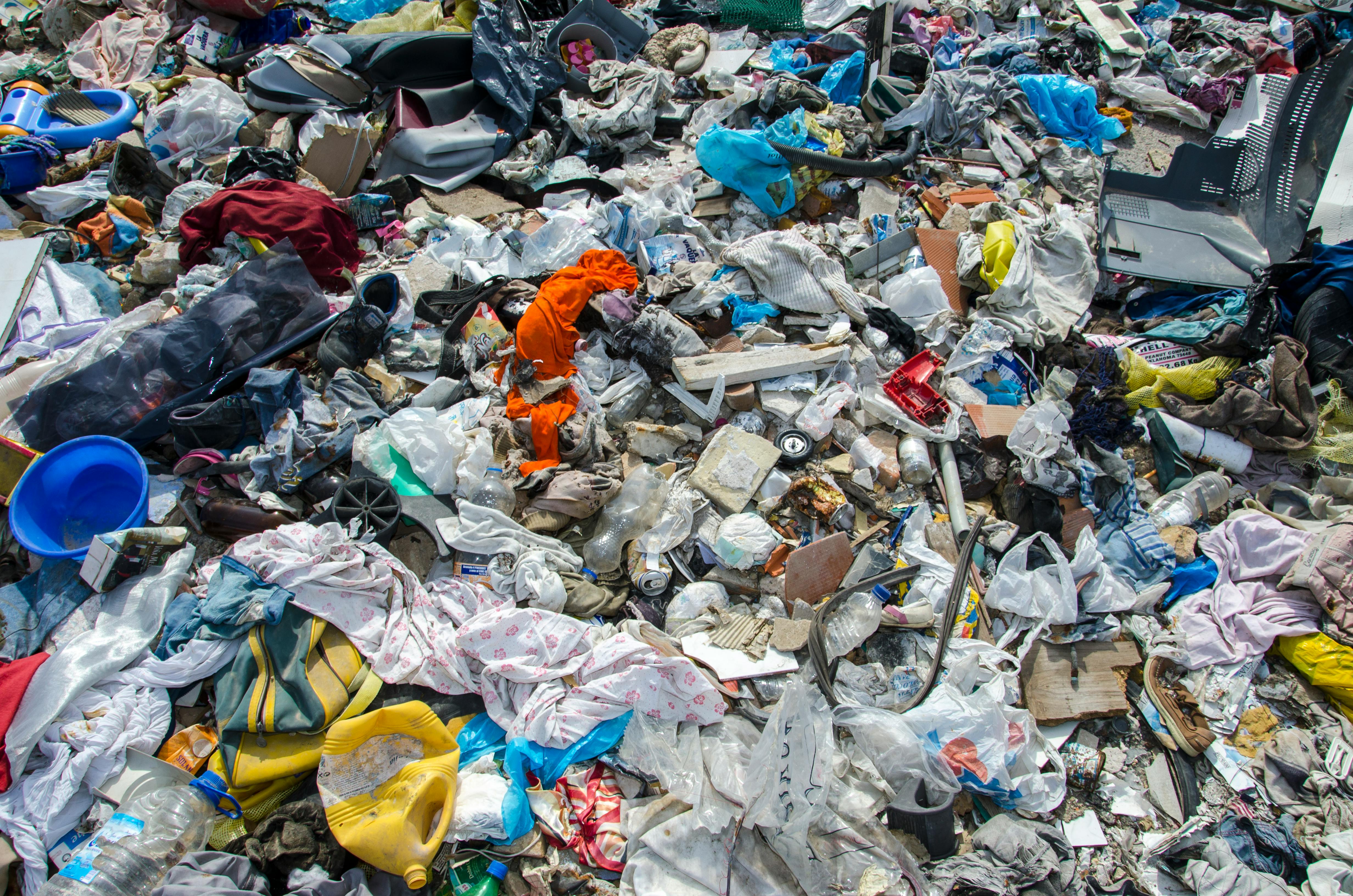 A variety of waste materials scattered at a landfill, highlighting environmental concerns.